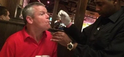 Man with cerebral palsy has trouble eating. Waiter voluntarily feeds him without hesitation