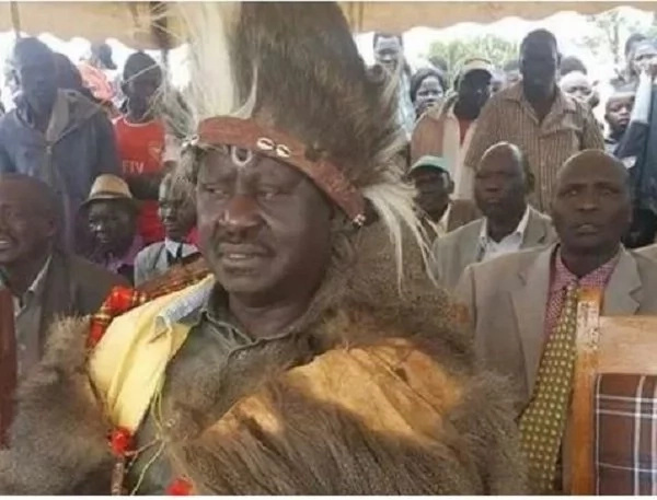 Woman stands near Raila in Jubilee T-shirt