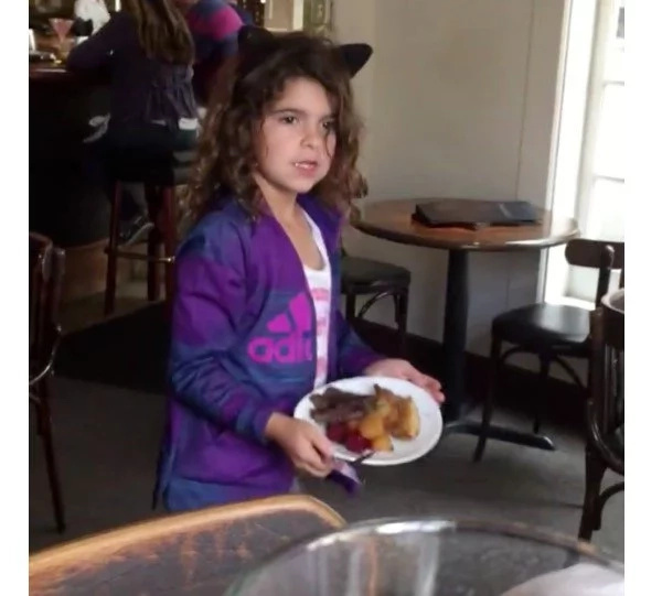 Adorable young girl shares her dinner with homeless man outside restaurant Adorable young girl shares her dinner with homeless man outside restaurant