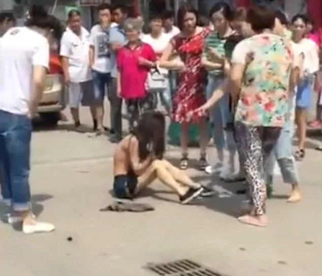 Angry woman beats, strips husband's mistress in public