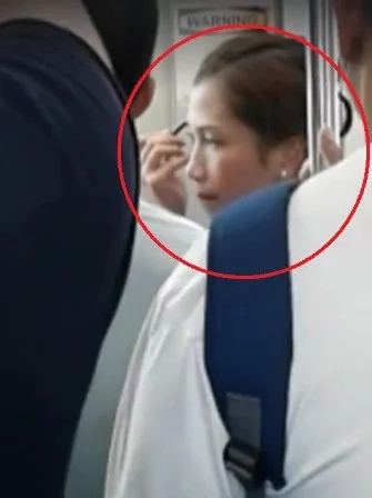Woman puts make-up while travelling through LRT Woman puts make-up while travelling through LRT