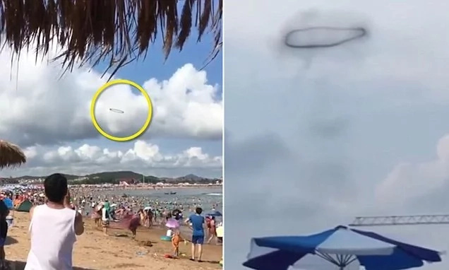 Is that a UFO? Swimmers puzzled by black ring that hovered in the clouds above the beach
