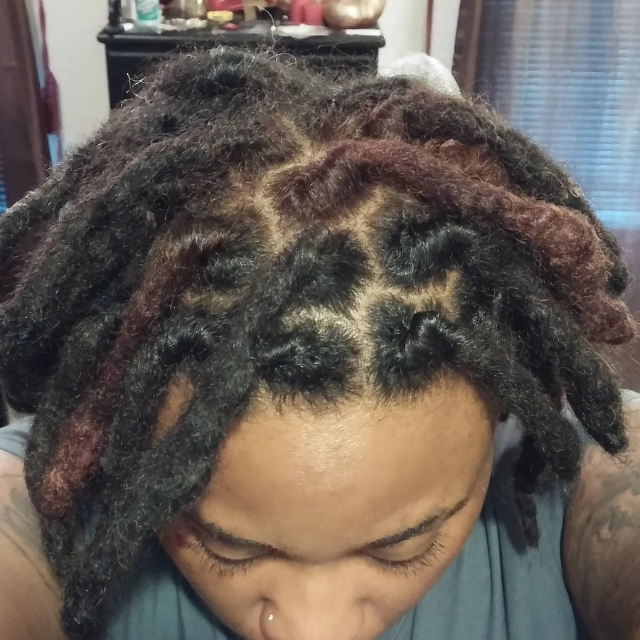 Half shaved hairstyle with short dreads. 