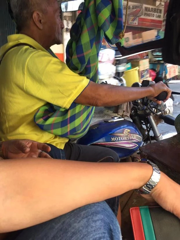 Father cradles toddler while working as tricycle driver Father cradles toddler while working as tricycle driver