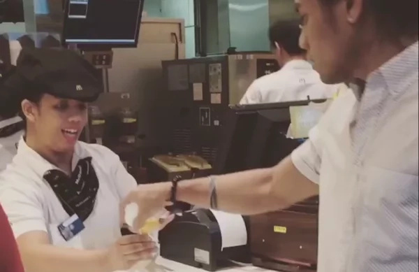 Customer surprises employee with grabbing ice cream by the hand Customer surprises employee with grabbing ice cream by the hand