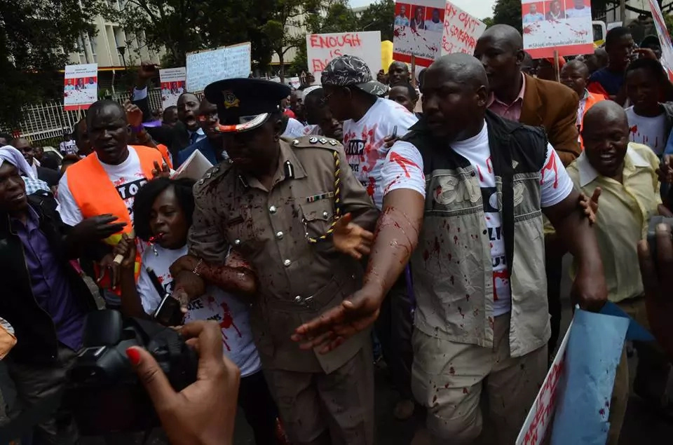 Protestors pour red paint on police spokesperson Charles Owino