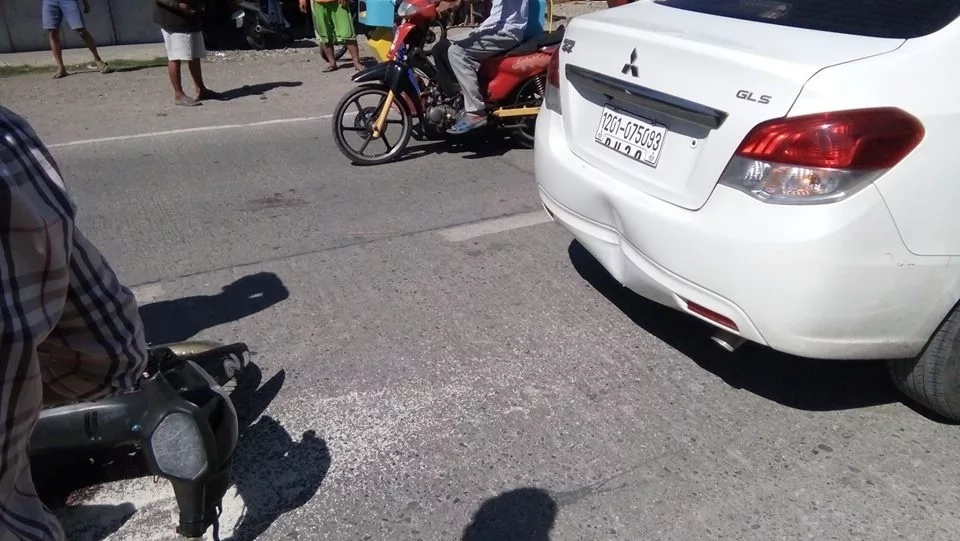 A motorcycle crashed behind a sedan damaging its rear. Car owner decides to compensate for the rider. A motorcycle crashed behind a sedan damaging its rear. Car owner decides to compensate for the rider.