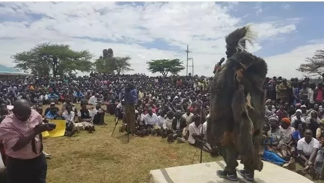 Woman stands near Raila in Jubilee T-shirt