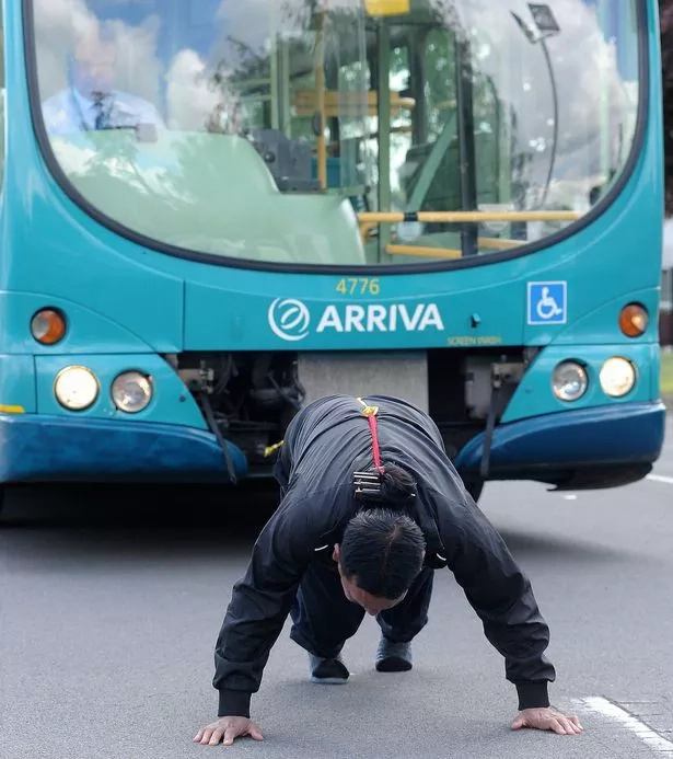 Grandad breaks own world record, pulls giant bus with ponytail