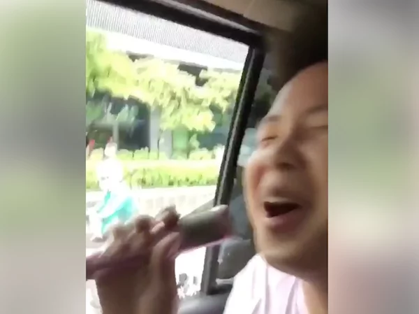 Filipino entertains by singing to the public inside a car while traffic Filipino entertains by singing to the public inside a car while traffic
