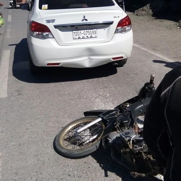 A motorcycle crashed behind a sedan damaging its rear. Car owner decides to compensate for the rider. A motorcycle crashed behind a sedan damaging its rear. Car owner decides to compensate for the rider.