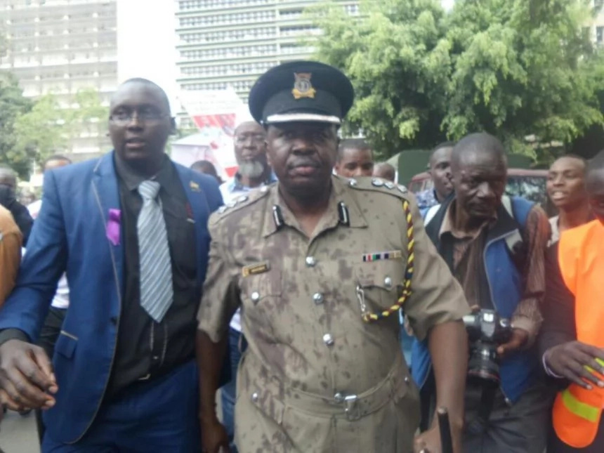 Protestors pour red paint on police spokesperson Charles Owino