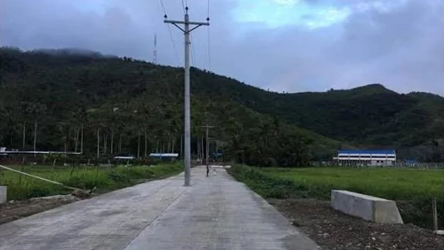 Electric posts stand in the middle of Tacloban road