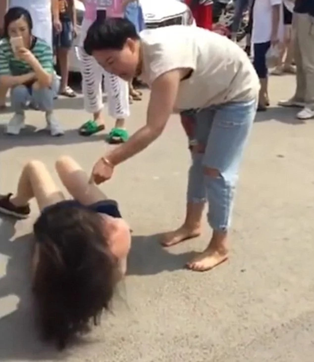 Angry woman beats, strips husband's mistress in public