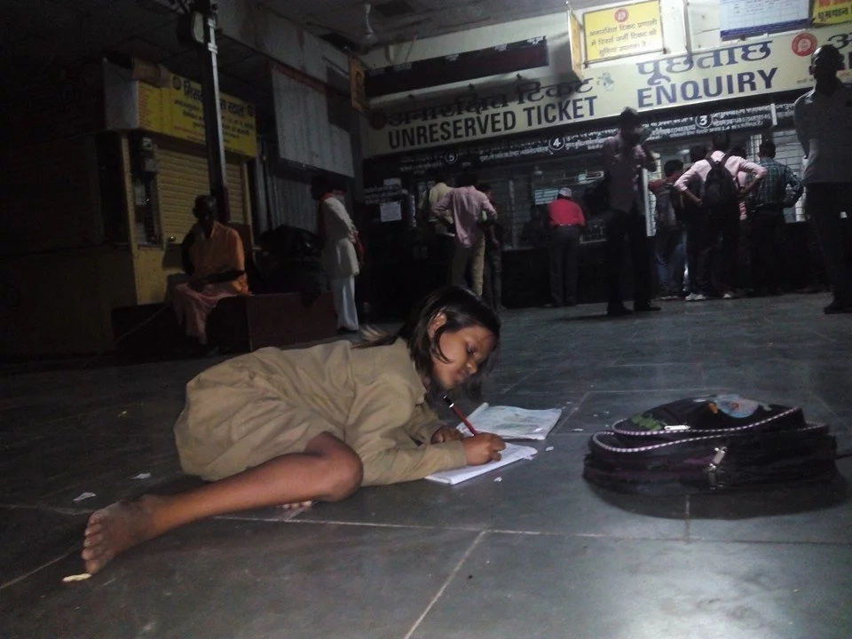 Divya takes advantage of the light at the railway station to study every night Divya takes advantage of the light at the railway station to study every night