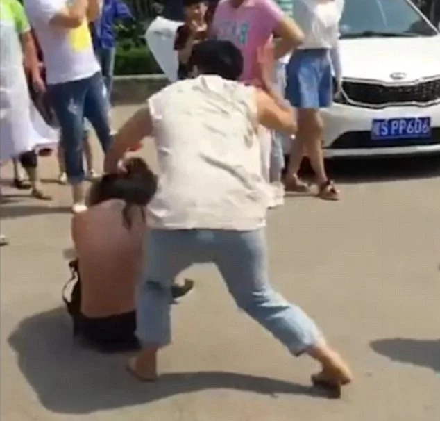 Angry woman beats, strips husband's mistress in public