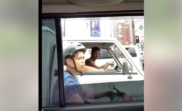 Filipino entertains by singing to the public inside a car while traffic Filipino entertains by singing to the public inside a car while traffic